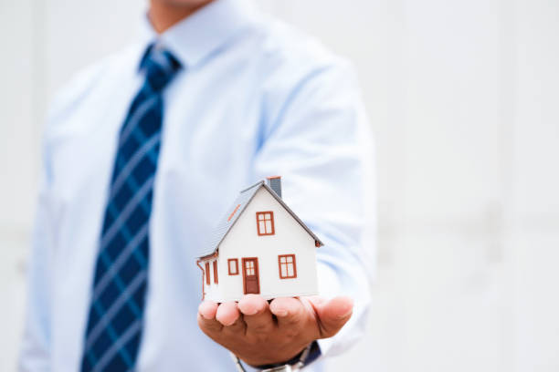 istock Real Estate Agent Protecting House Model in Hand 2188967331