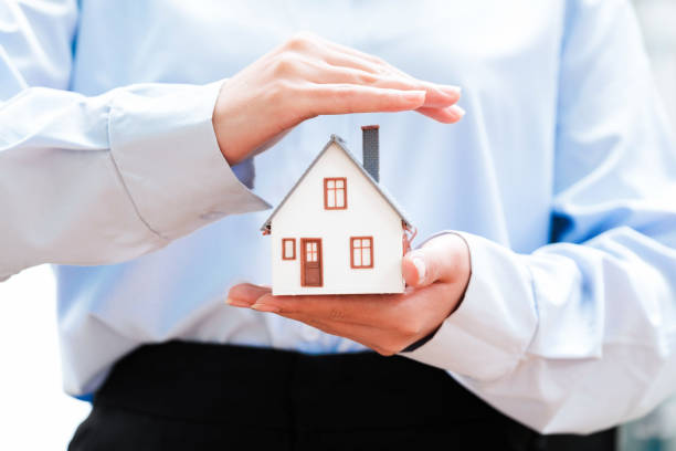 istock Real Estate Agent Protecting House Model in Hand 2188967333