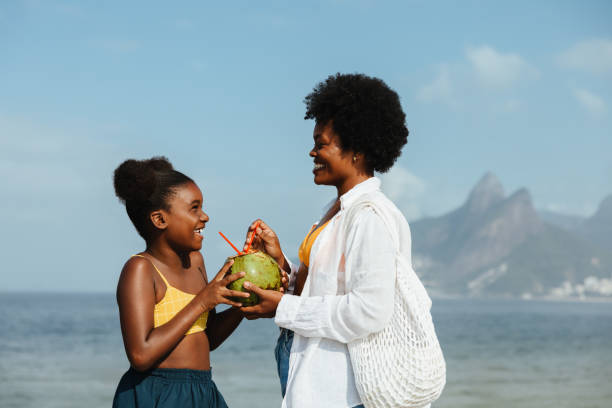 istock Mother and daughter sharing a coconut on Ipanema Beach 2188971139