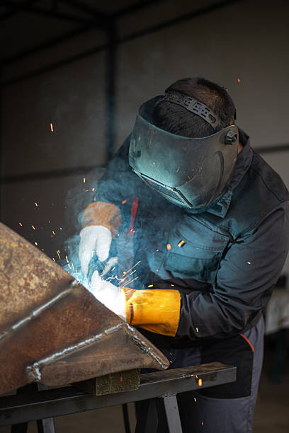 istock Worker welding metal with sparks flying in workshop 2188971832