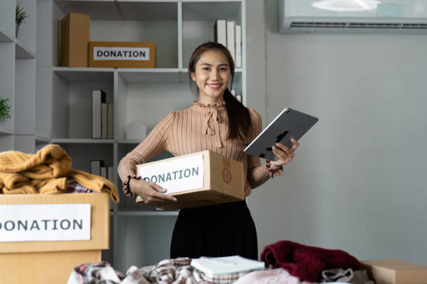 istock Smiling Woman Organizing Donations with Tablet in Modern Office Setting 2188975115