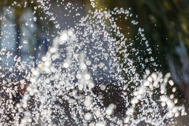 A spray of water is falling from the sky, creating a misty and refreshing atmosphere. The water droplets are scattered in various directions, creating a sense of movement and energy