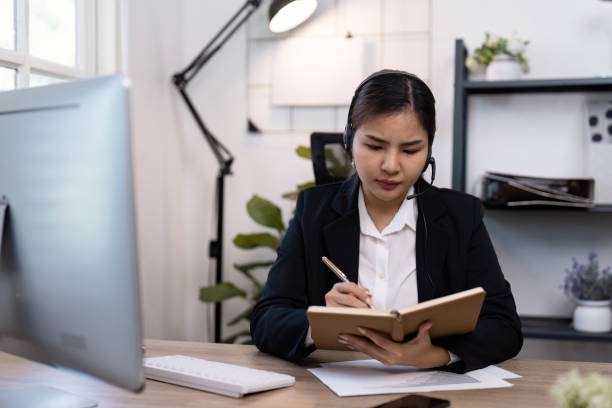 istock Professional Businesswoman Working in Modern Office with Headset and Notebook for Effective Communication and Organization 2188975898