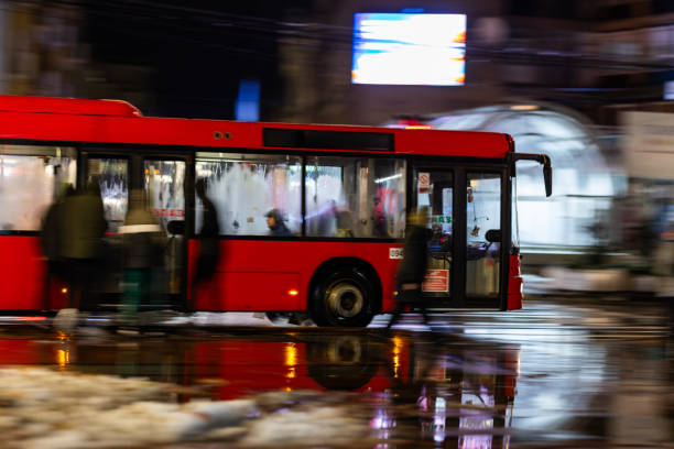 Bus stopping at bus station during rainy evening in the city