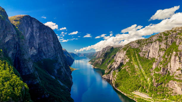 Kjerag, Lysebotn, Lysefjorden, Norway, A breathtaking view of a Norwegian fjord, showcasing towering cliffs, lush greenery, and the crystal-clear waters of the fjord A breathtaking view of a Norwegian fjord, showcasing towering cliffs, lush greenery, and the crystal-clear waters of the fjord. Kjerag, Lysebotn, Lysefjorden, Norway in summer geirangerfjord stock pictures, royalty-free photos & images