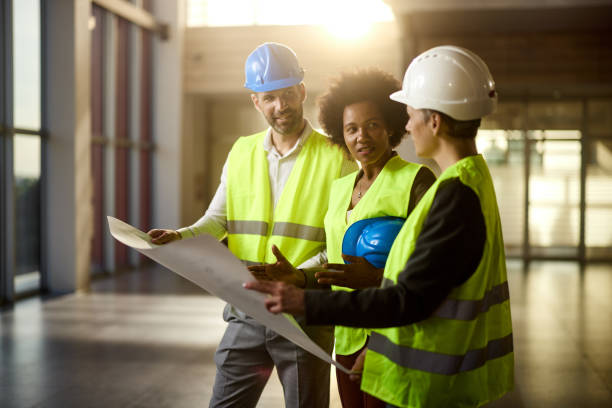 istock Team of happy civil engineers talking about plans at construction site. 2188977199