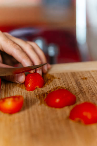 istock a chief is cutting tomato with a knife on a cutting board 2188979000