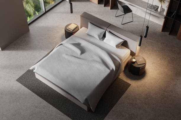 istock Modern bedroom interior with a minimalist bed, two side tables, and large windows. Clean lines and neutral tones create a serene home vibe. 3D Rendering 2188983051