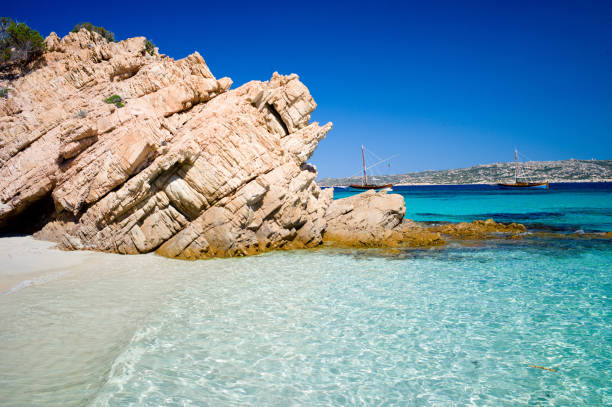 Grande Pevero beach with turquoise clear water and boats in Sardinia, Italy