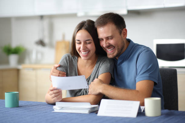 Happy couple checking bills at home stock photo