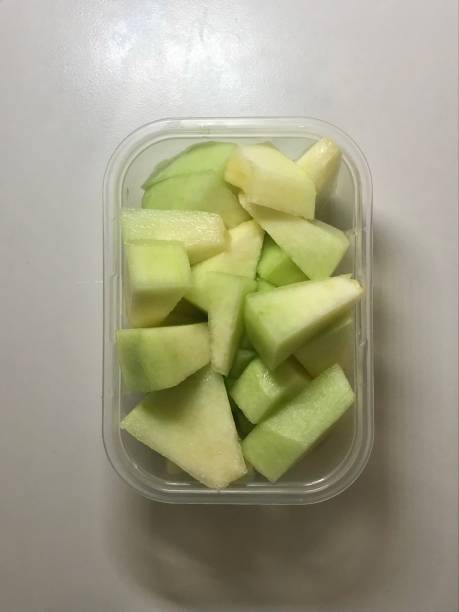 Fresh melon cubes neatly arranged in a bowl, showcasing their vibrant orange and green hues. A refreshing and visually appealing treat, perfect for any occasion.