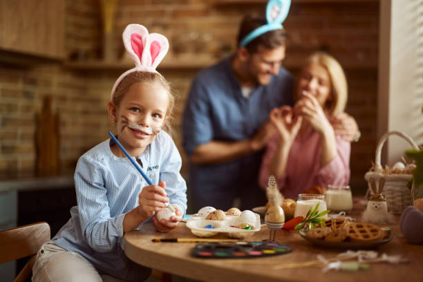 istock Happy girl coloring Easter eggs in dining room. 2188986818