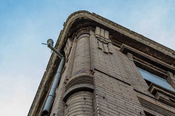 Close-up on a side wall of a building with chimney and deep blue sky beyond.