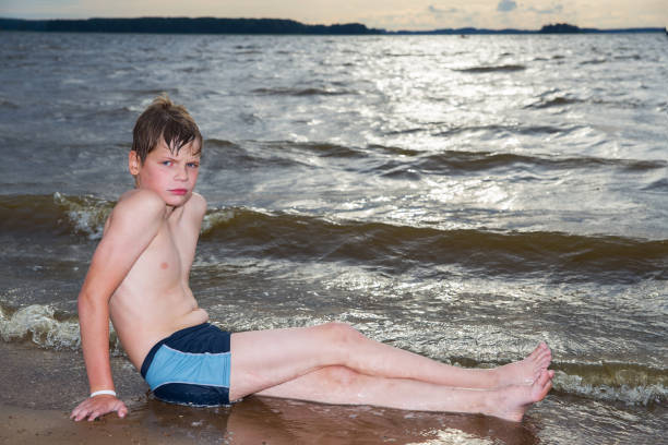 A boy swims in the sea. Cloudy weather.