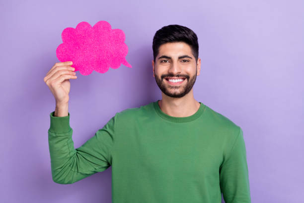 istock Photo of handsome toothy beaming cheerful man wear green pullover holding mind cloud empty space isolated on violet color background 2188991828