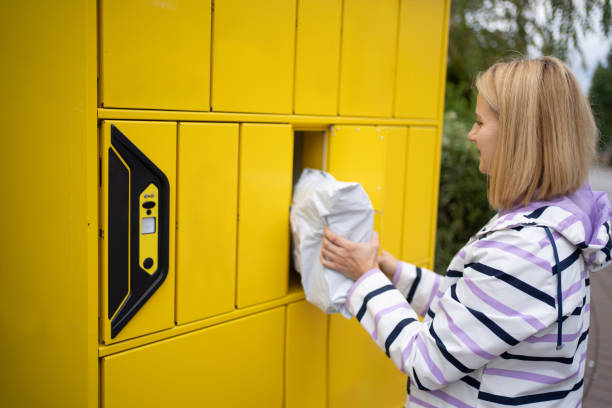 Woman picking up package from automated self-service parcel terminal locker