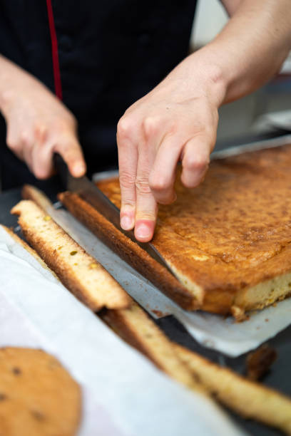 istock Professional pastry chef cutting a cake with precision, creating delectable desserts in a commercial kitchen 2188994934