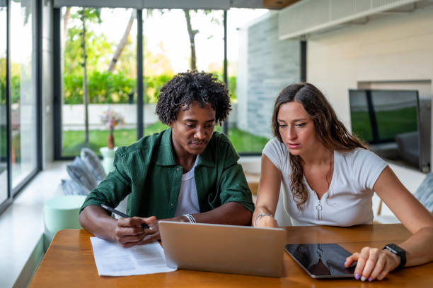istock Focused Young Professionals Collaborating On A Laptop At Modern Home Office 2188995025