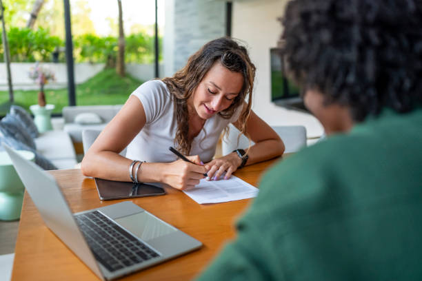 istock Focused Woman Writing on Paper in Modern Home Environment 2188995878