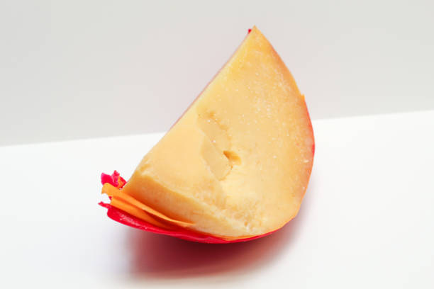 Edam cheese coated with red paraffin wax, isolated on white background
