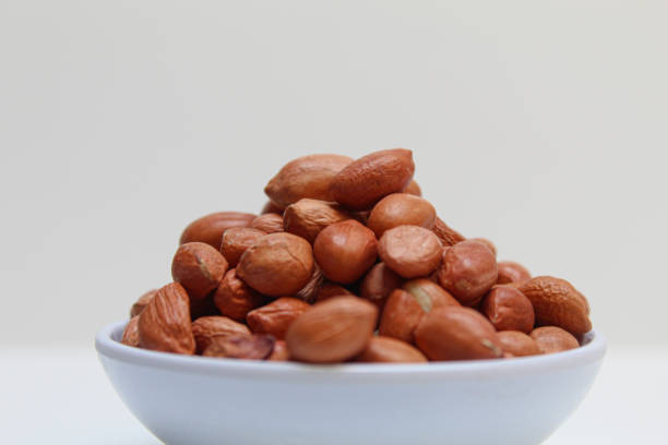 istock Peanuts or groundnut, or goober, or monkey nut. Peeled peanuts with thin red skin. Isolated on white background 2188996704