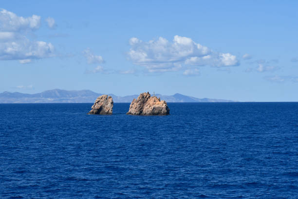 Greece, rocks in the sea at the entrance to Paros with a lighthouse for the safety of shipping
