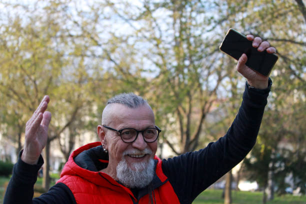 istock Modern senior man walking on street and using phone 2189001686