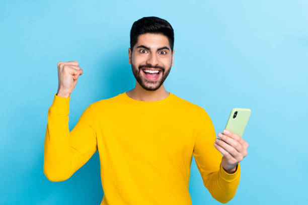 istock Photo of lucky pretty guy dressed yellow pullover typing modern gadget isolated blue color background 2189003532