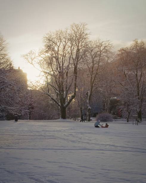 A mother is playing with her child in the snow
