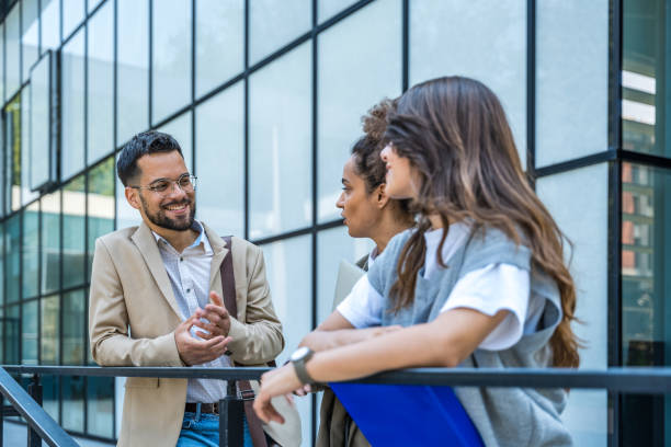 istock Group of modern successful business people innovative technology experts standing out of office building, discussing ideas and innovations. Leaders in global marketing strategy professional occupation 2189007819