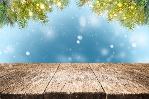 istock Empty wood table with pine branches and bokeh lights on blue winter background with snow. Christmas holiday backdrop. 2189008616