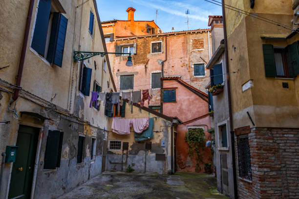 Old houses in city of Venice, Italy. Castello sestiere (district) residential architecture, small yard, aged facades and laundry drying outside.