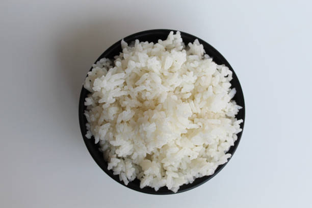 istock White rice on black bowl, isolated on white background 2189010793