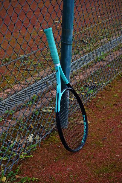 istock Tennis Racket Behind a Blue Metal Fence 2189010894