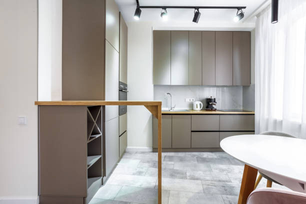 istock Modern kitchen in a small cozy contemporary studio apartment. Table and chairs in the foreground. Built in household appliance 2189015099