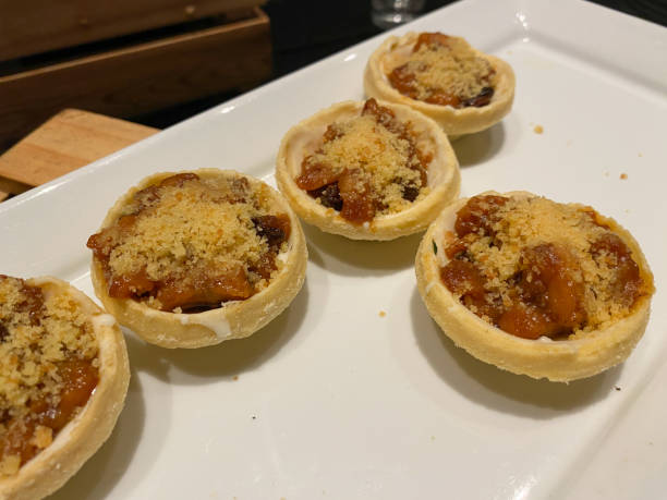 istock Mini pie crust filled with banana crumble, on a white plate 2189015439