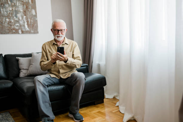 istock Smiling Elderly man grandfather using smart phone, searching web, loading feed, social media. Communication with children, grandchildren on lockdown 2189015687