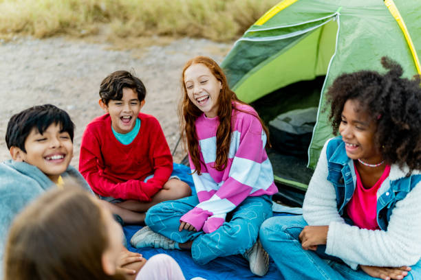 Child friends talking and camping outdoors