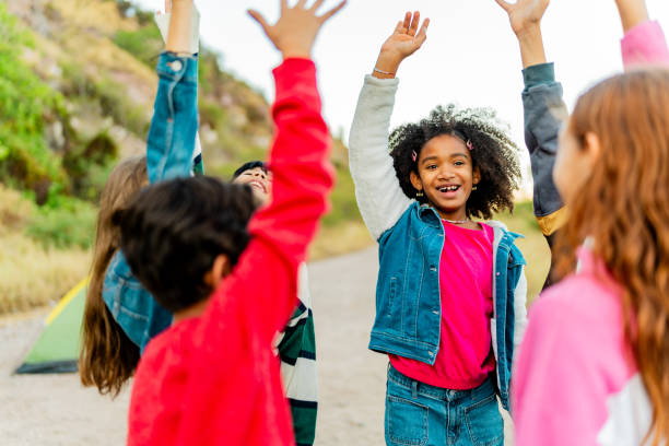 istock Child friends celebrating with arms raised during summer camp 2189016163