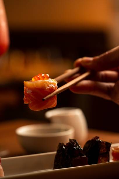 istock Chopsticks holding sushi in warm ambiance 2189016166