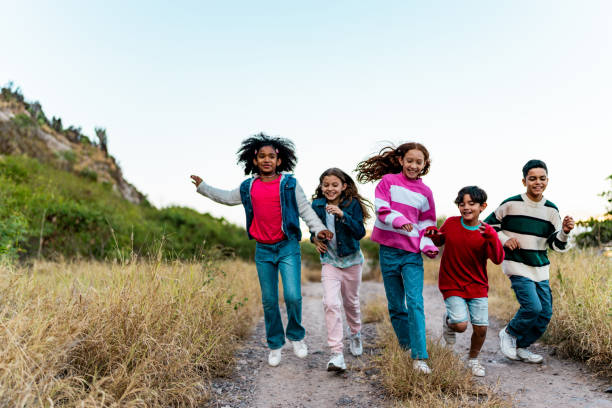 three children playing in the field in summer. young children playing outdoors smiling. happy family. carefree childhood.