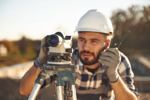 istock On the radio, with geodetic optical level. Worker is on the construction site at daytime 2189017567