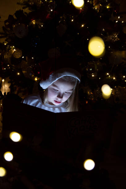 istock little girl in christmas tree 2189017840