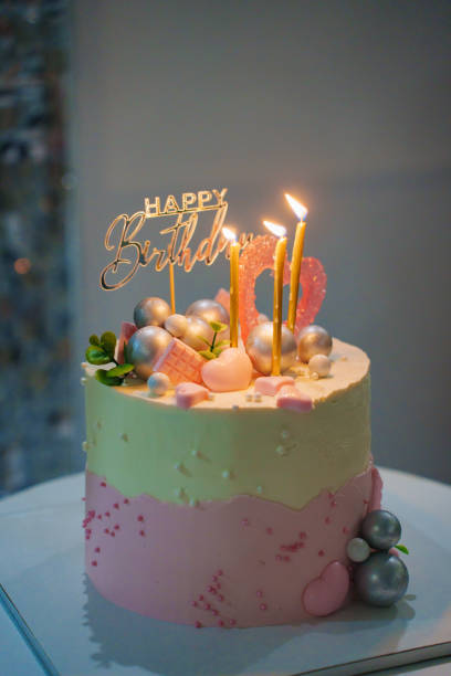istock White and pink birthday cake with candles and chocolate decor. 2189017883
