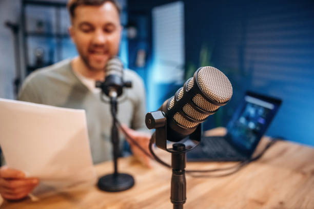 istock Reading the text. Man with microphone in the studio, conception of podcast 2189018786
