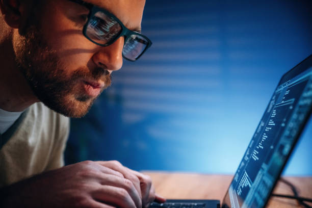 istock Side view. Male programmer is working indoors by a laptop 2189018869