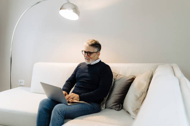 istock Mature adult man using laptop at home 2189022008