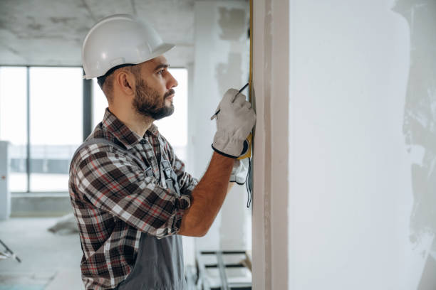 istock View from the side. A man is renovating an unfinished room 2189025594