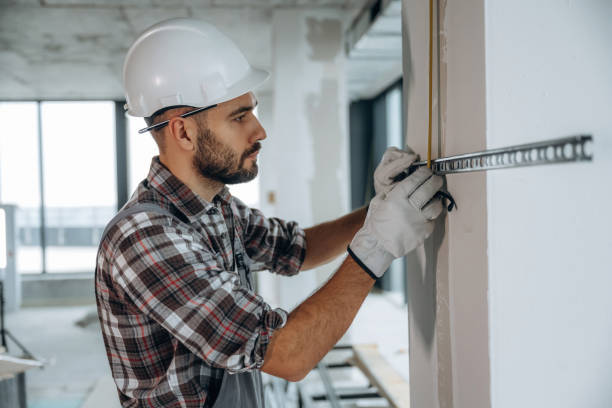 istock View from the side. A man is renovating an unfinished room 2189025642