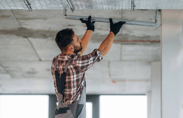 istock In gloves, ceiling work. A man is renovating an unfinished room 2189025645